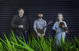 Mike McGoldrick, Niall McCabe and Nollaig Casey standing with their instruments