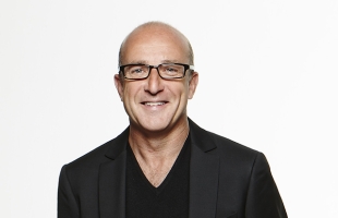 Headshot of Paul McKenna, wearing a black tshirt, and black blazer