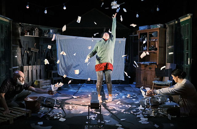 Image of Eleanor Walsh, as Grace, dancing in a swirl of paper.