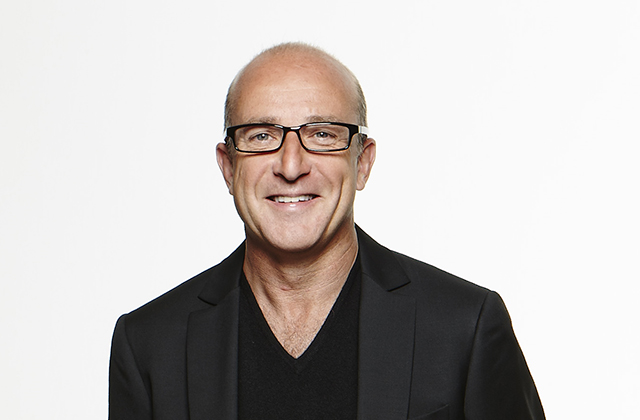 Headshot of Paul McKenna, wearing a black tshirt, and black blazer