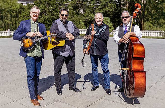 The Special Consensus outdoors in a Chicago park. They are dressed smartly, smiling, and holding their instruments.